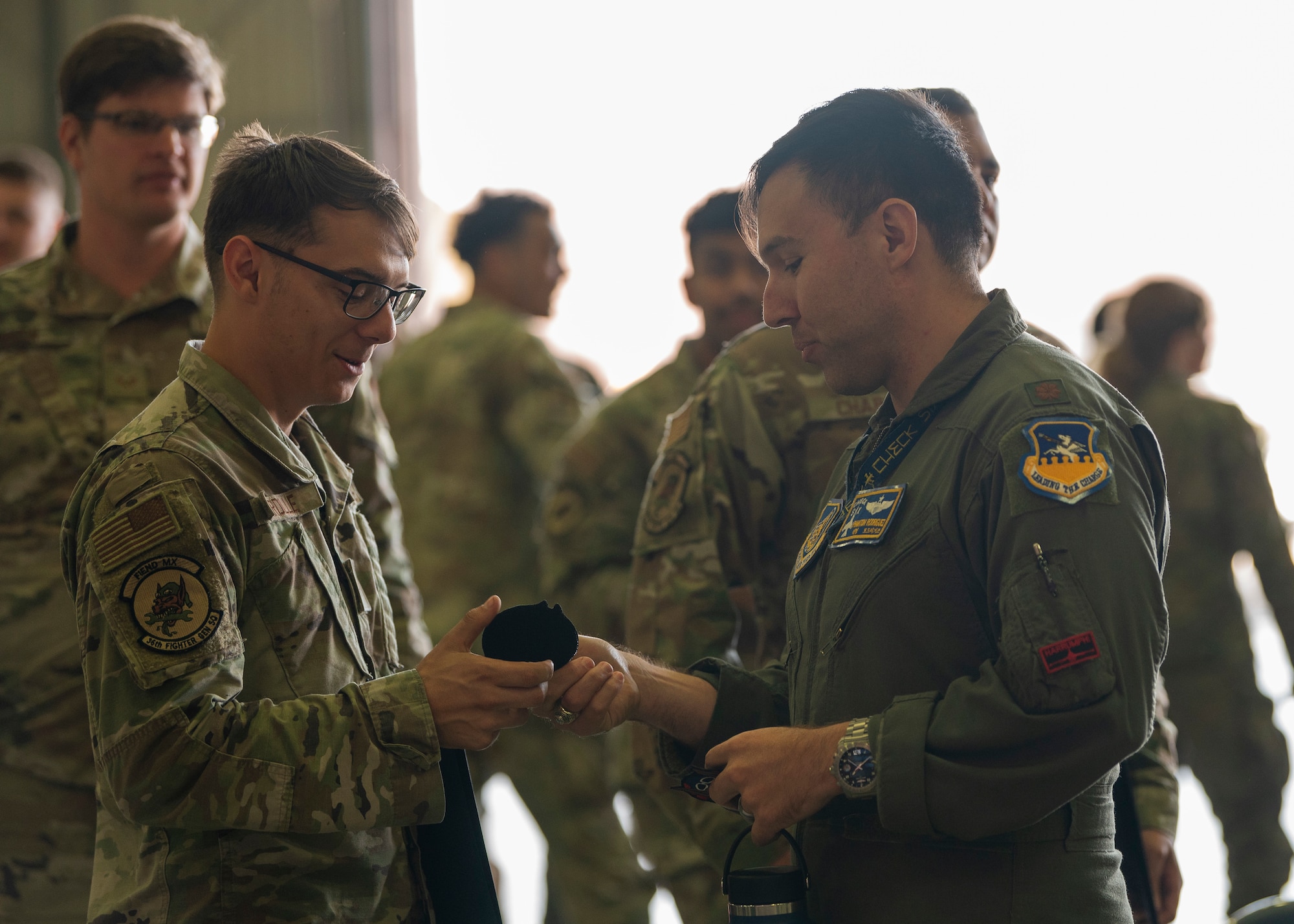 A U.S. Air Force pilot assigned to the 36th Fighter Squadron gives a patch to a newly appointed dedicated crew chief after a Dedicated Crew Chief Ceremony at Osan Air Base, Republic of Korea, Oct. 25, 2024. The DCC Ceremony is a time honored tradition held to celebrate the crew chiefs’ hard work and dedication to their craft. (U.S. Air Force photo by Staff Sgt. Ashley N. Mikaio)