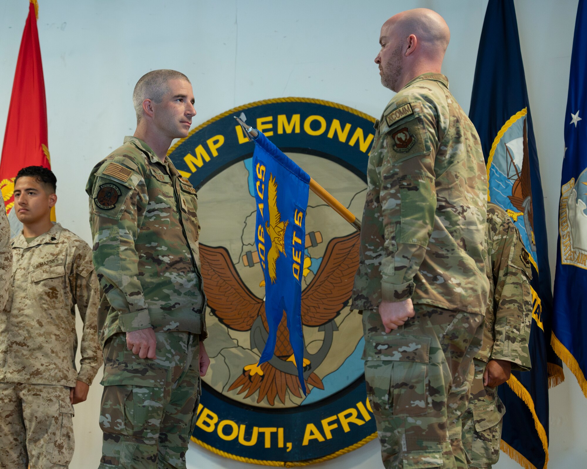 Members of the 606th Air Control Squadron stand with their uncased guidon.