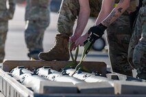 Airmen lift a munition onto a lift.