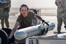 An Airman loads a munition on a lift truck.