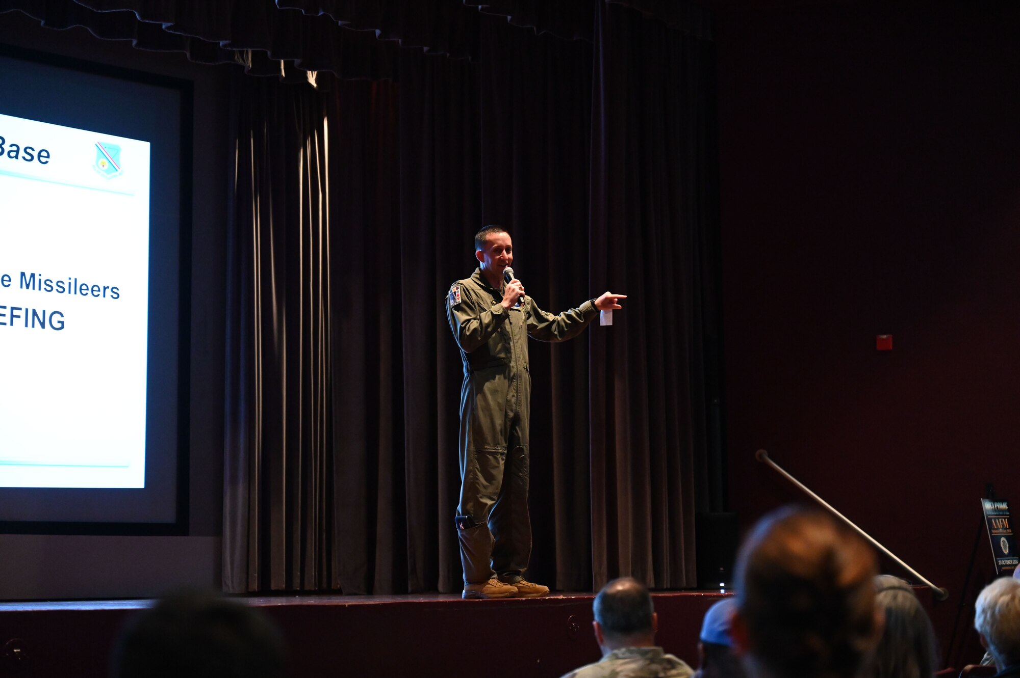 A man speaks on stage in a theater.