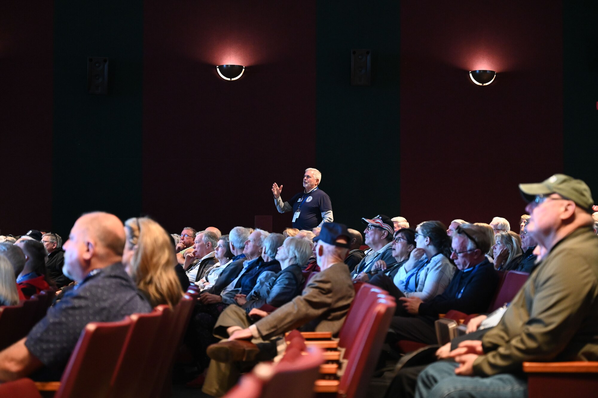 A person asks a question in a theater.