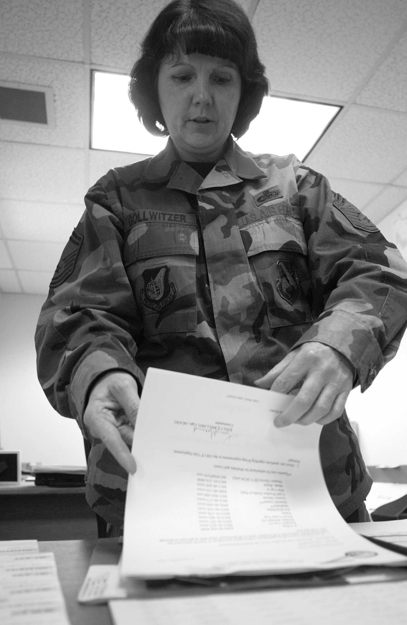 Chief Master Sgt. Cindy Gollwitzer, 168th Communications Flight, sifts through documentation to ensure the wing is taken care of, technology is upgraded, and Airmen are taken care of.