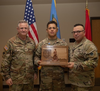 Spc. Juan Lopez, a Stillwater, Oklahoma resident serving as a signal operations support specialist in the 1st Battalion, 160th Field Artillery Regiment, 45th Infantry Brigade Combat Team, poses with Command Sgt. Maj. John Hernandez, the state command sergeant major for Oklahoma, and Brig. Gen. Brad Carter, assistant adjutant general - Army for Oklahoma, after Lopez was named the 2025 Oklahoma Army National Guard Soldier of the Year at Camp Gruber Training Center, Oklahoma, Nov. 8, 2024. (Oklahoma National Guard photo by Spc. Cambrie Cannon)