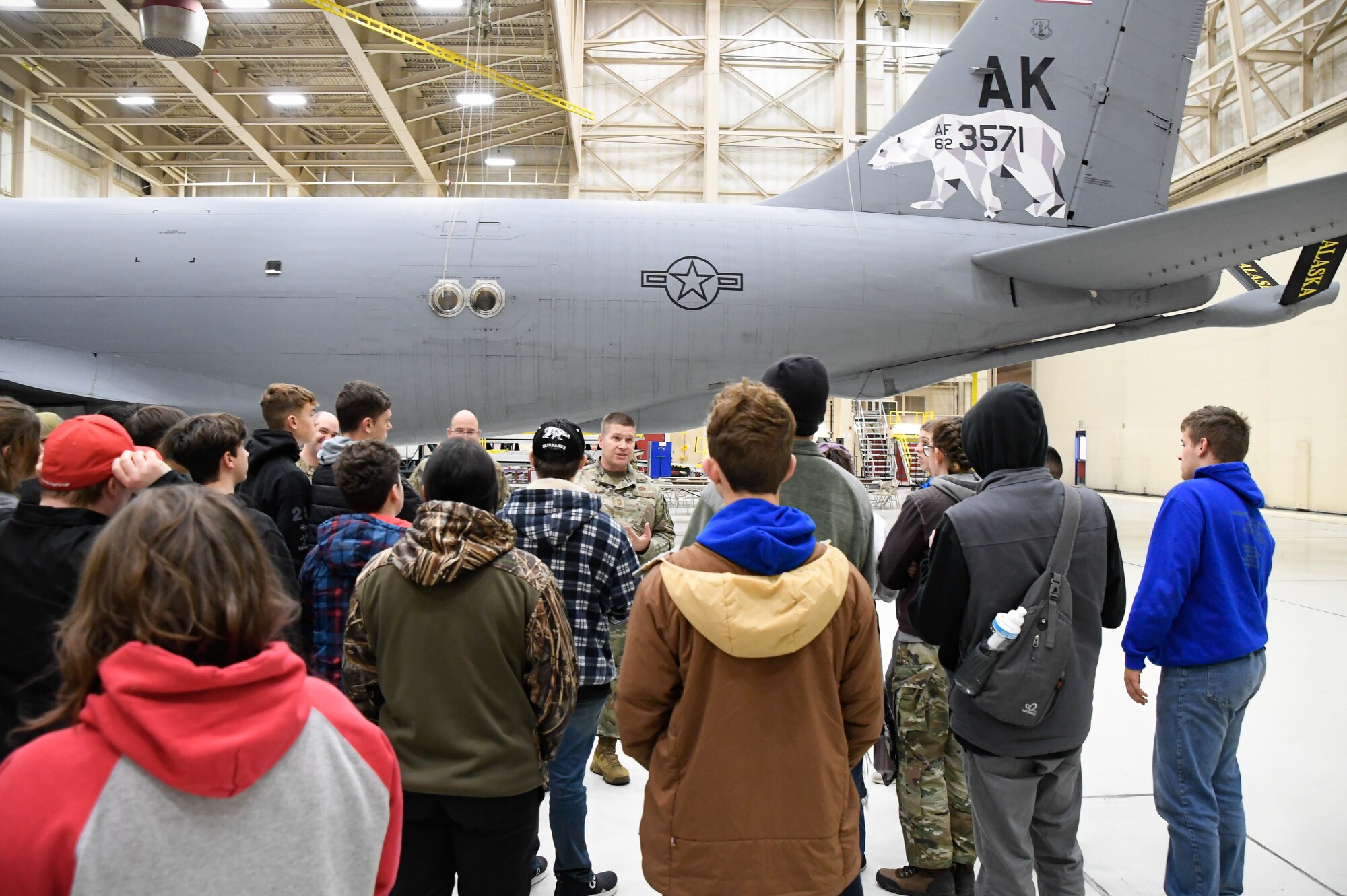 U.S. Air National Guard Chief Master Sgt. Ray Allen of the 168th Maintenace Group discusses the 168th Air Refueling mission with the North Pole Junior Reserve Officer Training Corps students during a tour of the 168th Wing at Eielson Air Force Base, Oct. 17, 2024.