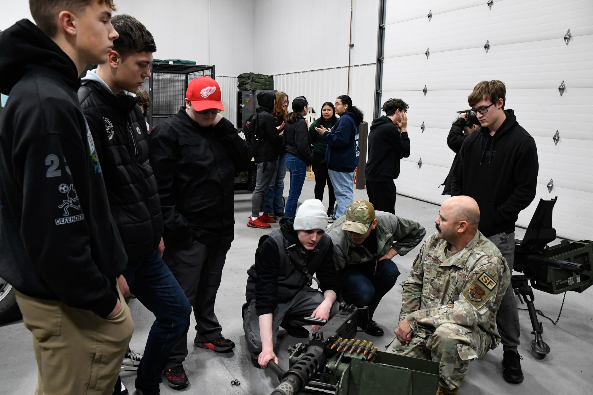 Senior Master Sgt. Jeremy Amstrup, 168th Security Forces, discusses weapons with the  North Pole Junior Reserve Officer Training Corps students.