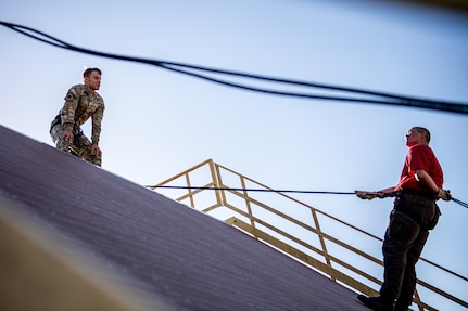 Sgt. 1st Class Matthew Ribero, a member of 1st Squadron, 180th Cavalry Regiment, 45th Infantry Brigade Combat Team, and qualified rappel master, coaches a Thunderbird Challenge Program cadet during TCP’s field day at Camp Gruber Training Center, Oklahoma, Oct. 25, 2024. The Thunderbird Challenge Program is a 22-week tuition-free program operated by the Oklahoma Military Department and Oklahoma National Guard that provides Oklahoma students in need of school credit recovery with military-based structure, high school or GED classes, college courses, job training and essential life skills. (Oklahoma National Guard photo by Anthony Jones)