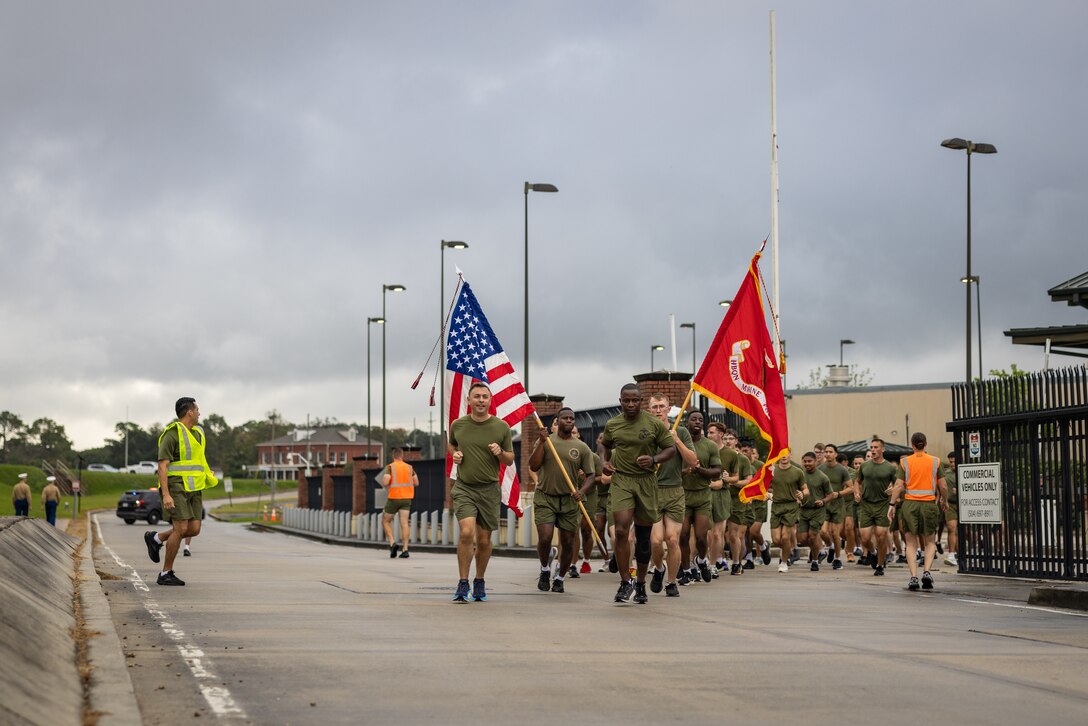 U.S. Marines assigned to Marine Forces Reserve run through the gates of Marine Corps Support Facility, New Orleans during an annual motivational run celebrating the 249th birthday of the U.S. Marine Corps led by Col. Anthony Sferrazza, left, and Sgt. Maj. Kabiru Labaran, in New Orleans, Nov. 7, 2024. The run started at the MCSF, New Orleans and traveled along the Mississippi River ending back at MCSF. The run celebrates the history of the Marine Corps and creates esprit de corps and comradery among Marines.  (U.S. Marine Corps photo by Sgt. Scott Jenkins)
