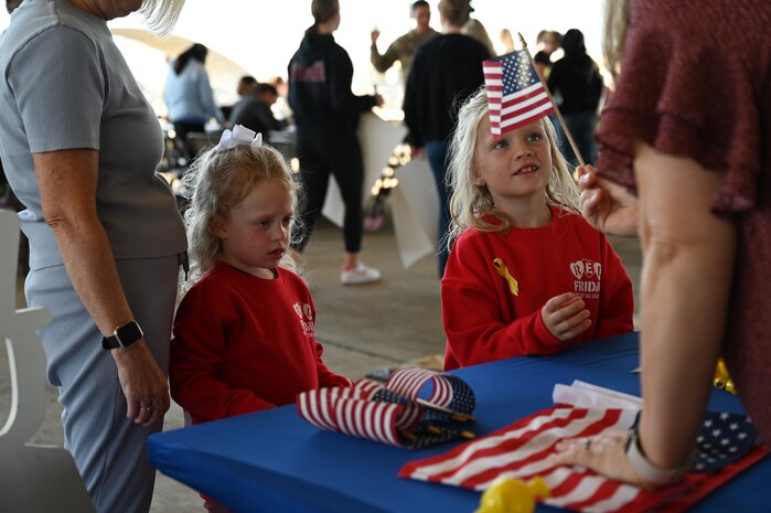 Magnolia Anderson, 5 years old, receives a U.S. Flag during a farewell event at the flightline on Beale Air Force Base, California, Sept. 27, 2024.