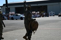 A U.S. Air Force Airman waves at a crowd of friends and families as he prepares to take off in a Boeing 767-300 from the flightline on Beale Air Force Base, California, Sept. 27, 2024.
