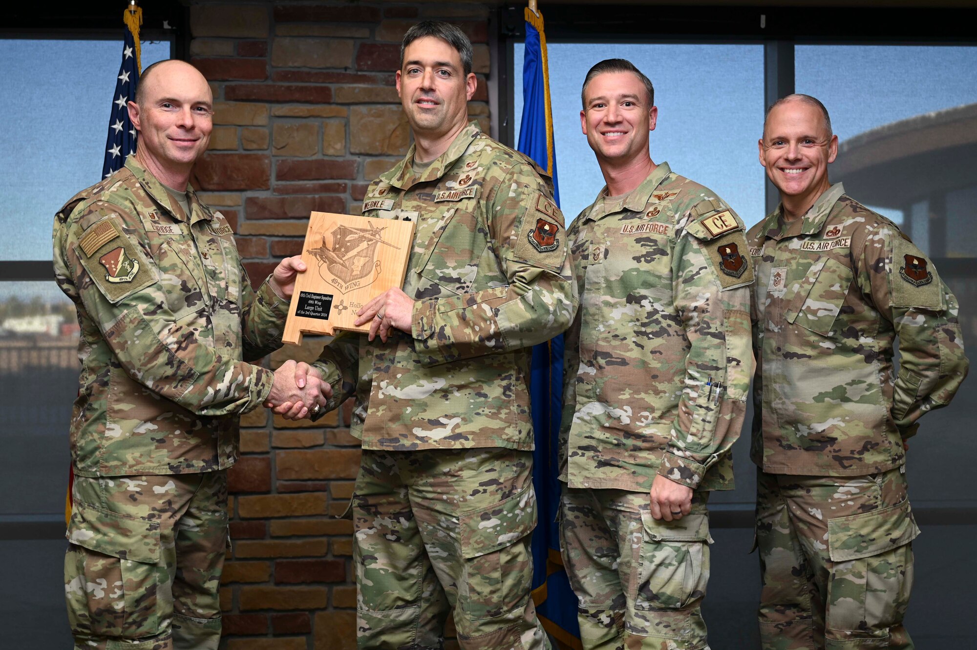 U.S. Air Force Lt. Col. Brian Wernle, 49th Civil Engineer Squadron commander and U.S. Air Force Senior Master Sgt. Justin Tite, 49th CES senior enlisted leader, accepts the 49th Wing’s Large Unit of the Quarter Award, during the 49th Wing’s 3rd Quarter Award ceremony at Holloman Air Force Base, New Mexico, Nov. 8, 2024. Quarterly award winners were selected based on their technical expertise, demonstration of leadership and job performance. (U.S. Air Force photo by Airman 1st Class Michelle Ferrari)