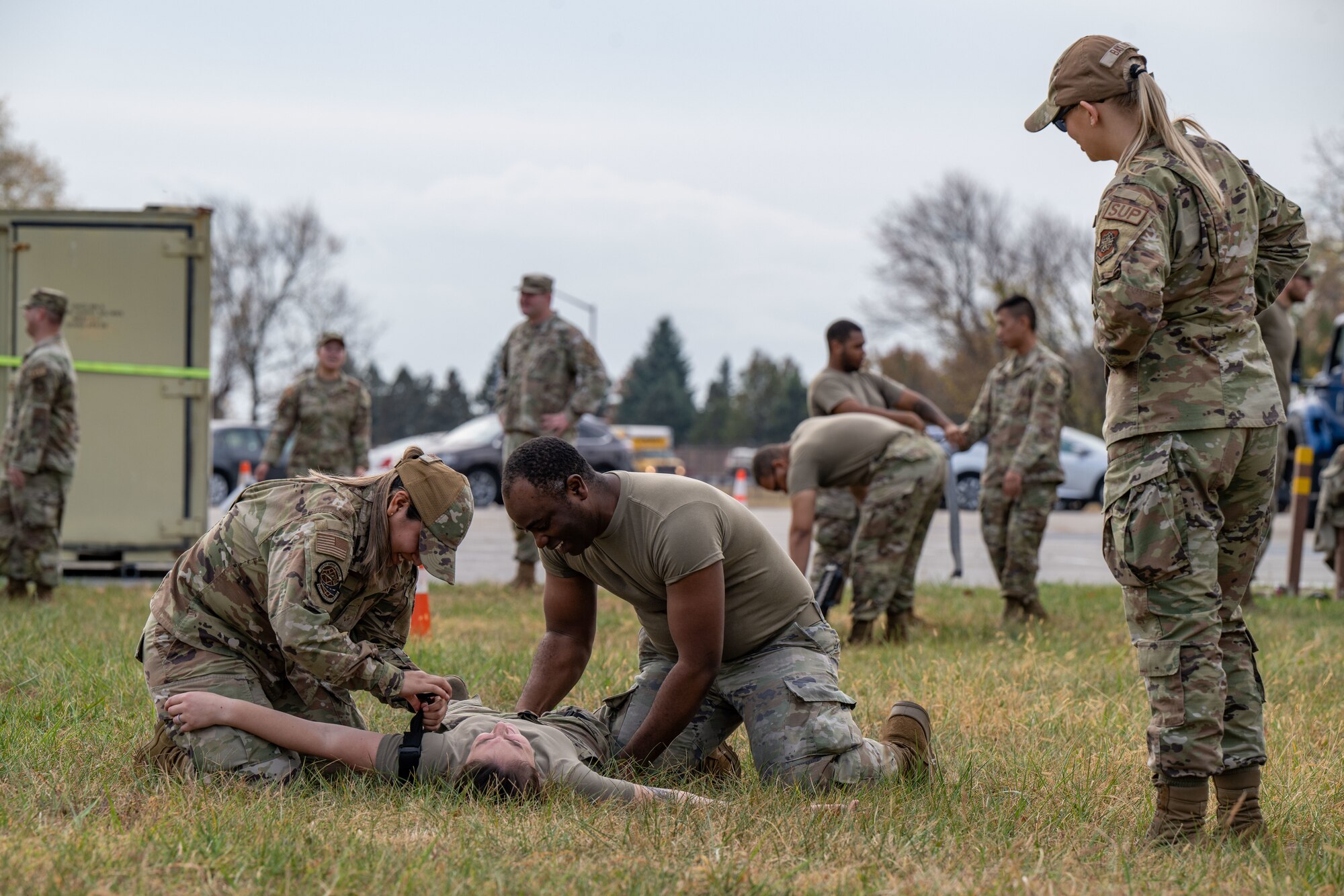 U.S. Air Force Senior Airman Zoey Baylor, right, 436th Logistics Readiness Squadron warehouse operations apprentice, supervises a team of Airmen performing Tactical Combat Casualty Care procedures during the LRS Mission Ready Airman Rodeo at Dover Air Force Base, Delaware, Nov. 7, 2024. The Rodeo consisted of three events intended to prepare Airmen for the future fight and meet MRA qualifications in a competitive, engaging and safe competition. (U.S. Air Force photo by Senior Airman Amanda Jett)