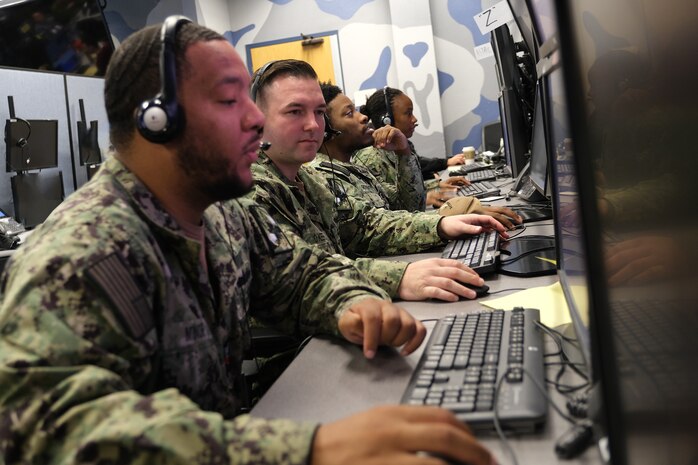 uniformed U.S. Navy Sailors work in a virtual simulated environment