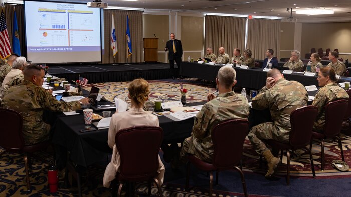 Man briefing people at u-shaped conference table