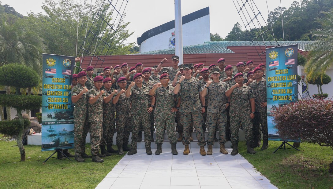 Service members with the Royal Malaysian Armed Forces, along with U.S. Marines attached to Marine Rotational Force-Southeast Asia, pose for a photo for an amphibious planning subject matter expert exchange during exercise Cooperation Afloat Readiness and Training Malaysia 2024 on Lumut Naval Base, Lumut, Malaysia, Oct. 31, 2024. CARAT Malaysia 2024 highlights the 30th anniversary of CARAT among allies and partners as a way to demonstrate long-term commitment to strengthened relationships throughout South and Southeast Asia and to highlight U.S. commitment to key Association of Southeast Asian Nations (ASEAN) partners to reinforce ASEAN Centrality. MRF-SEA is a rotational unit derived from elements of I Marine Expeditionary Force executing a U.S. Marine Corps Forces, Pacific operational model that involves training events and exchanges with partner military subject matter experts, promotes security goals with Allied and partner nations, and ensures a persistent I MEF presence west of the International Date Line. (U.S. Marine Corps photo by Cpl. Tyler Wilson)