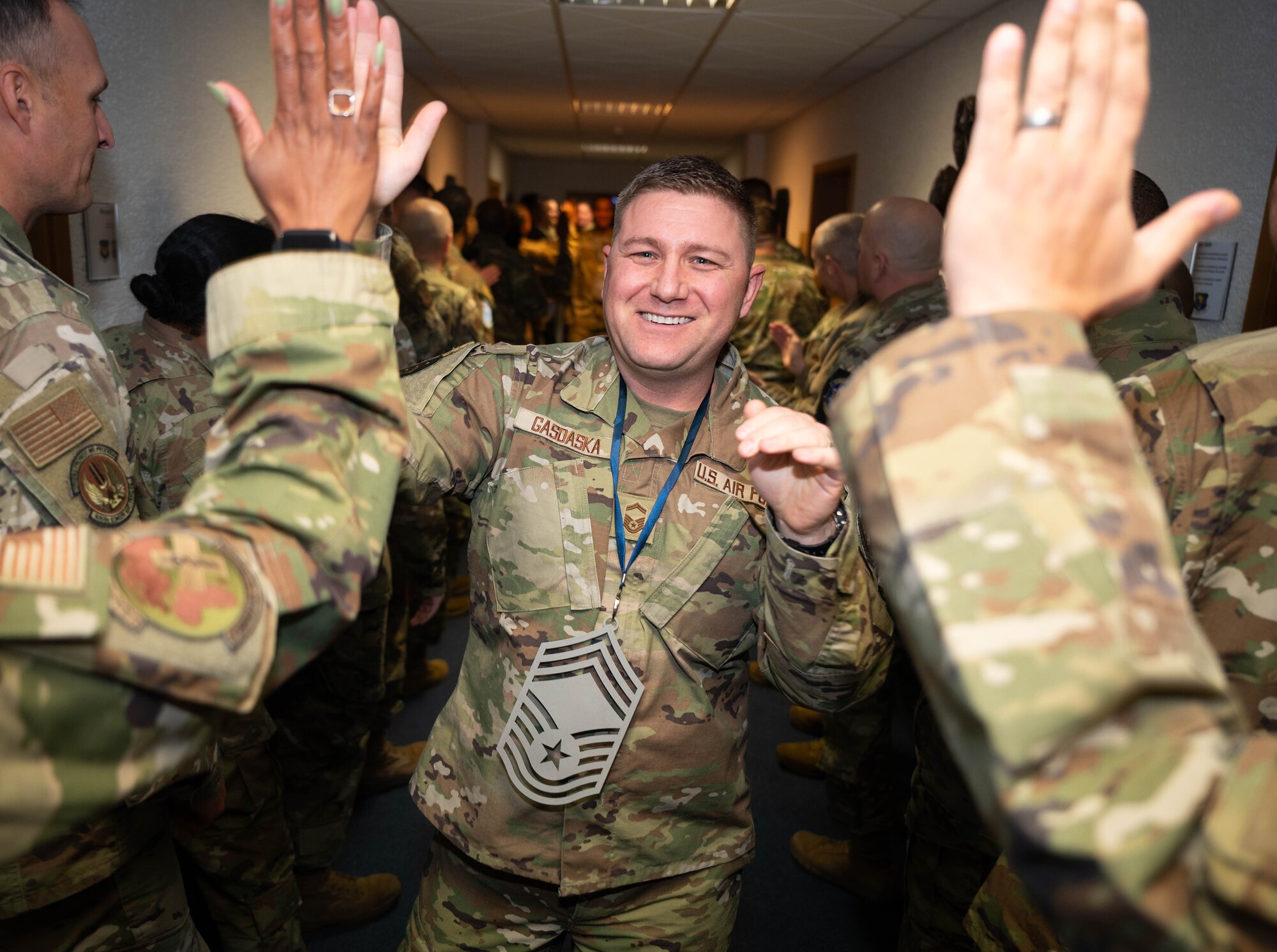 U.S. Air Force Airmen assigned to Ramstein Air Base, Germany, congratulate U.S. Air Force Senior Master Sgt. David Gasdaska, United States Air Forces in Europe-Air Forces Africa A4 command propulsion functional manager, on his promotion to Chief Master Sgt. at Ramstein AB, Nov. 7, 2024. Chief Master Sergeants congratulated promotion selectees before taking them to a release party. (U.S. Air Force Photo by Senior Airman Jared Lovett)
