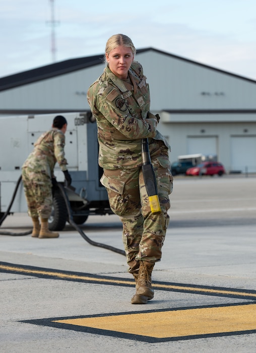 U.S. Air Force Senior Airman Hayley Bradley, 439th Civil Engineer Squadron engineering apprentice, pulls a power cord from an aerospace ground equipment aircraft generator during a “Spot Preparation” course challenge requiring the set up of three aircraft parking spots at Dover Air Force Base, Delaware, Nov. 7, 2024. The base hosted Wing Readiness Week consisting of events spread over three days that focused on strengthening readiness, resilience and team cohesion with events throughout the base. (U.S. Air Force photo by Roland Balik)