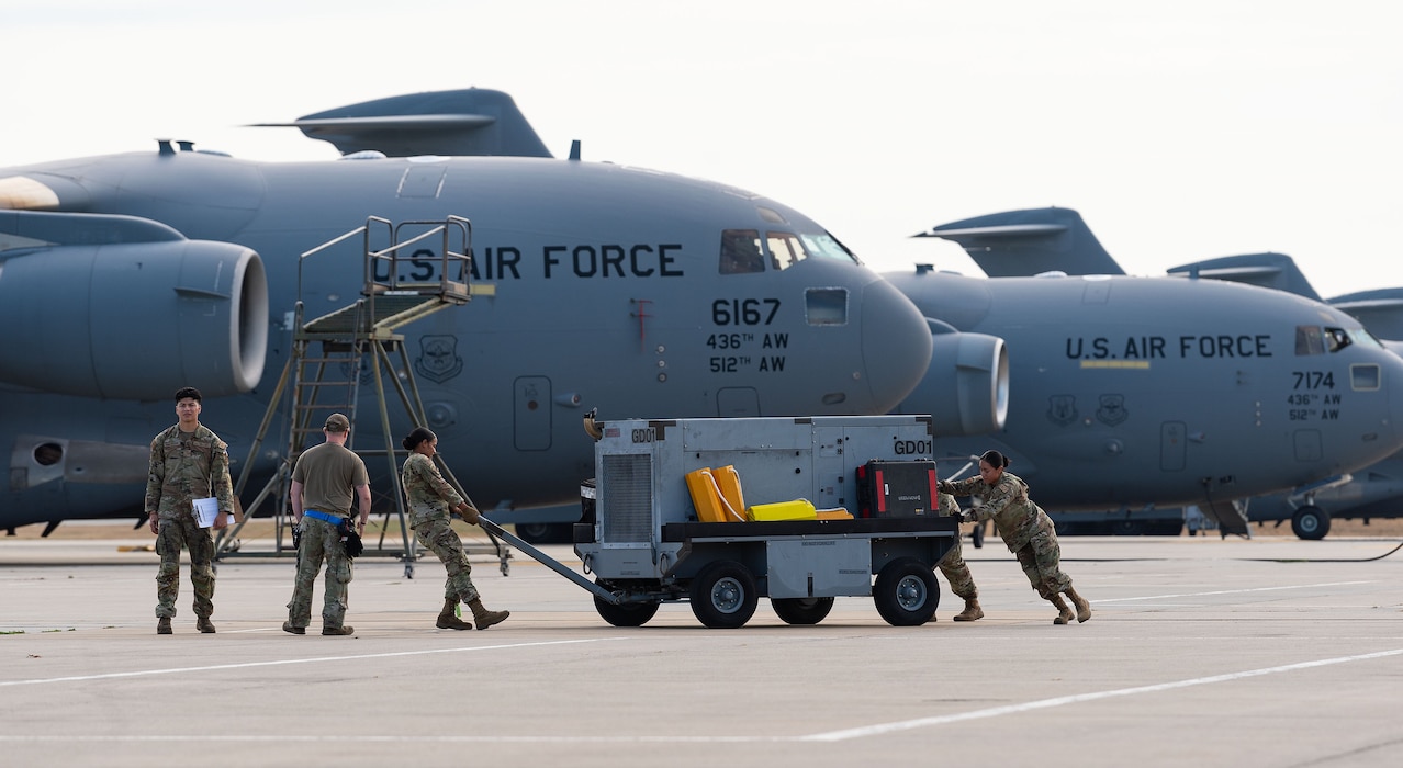 Team Dover members position an aerospace ground equipment aircraft generator during a “Spot Preparation” course challenge requiring the set up of three aircraft parking spots at Dover Air Force Base, Delaware, Nov. 7, 2024. The base hosted Wing Readiness Week consisting of events spread over three days that focused on strengthening readiness, resilience and team cohesion with events throughout the base. (U.S. Air Force photo by Roland Balik)