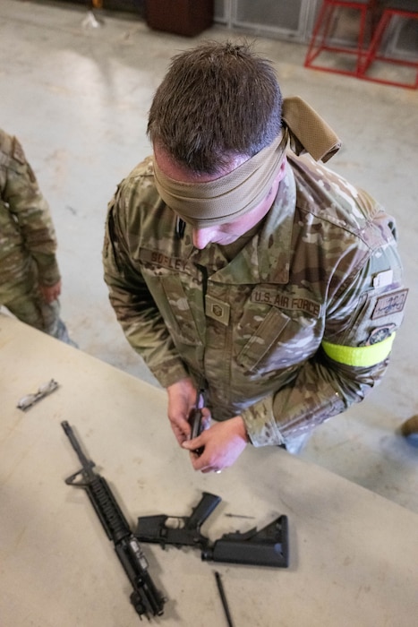 U.S. Air Force Master Sgt. Robert Sofley, 736th Aircraft Maintenance Squadron unit programs section chief, disassembles an M4 carbine while blindfolded during the 2024 Wing Readiness Week at Dover Air Force Base, Delaware, Nov. 6, 2024. Teams from various squadrons across the 436th Airlift Wing faced off in challenges designed to test their operational skills while emphasizing versatility and the ability to fill roles outside of normal duties. (U.S. Air Force photo by Mauricio Campino)