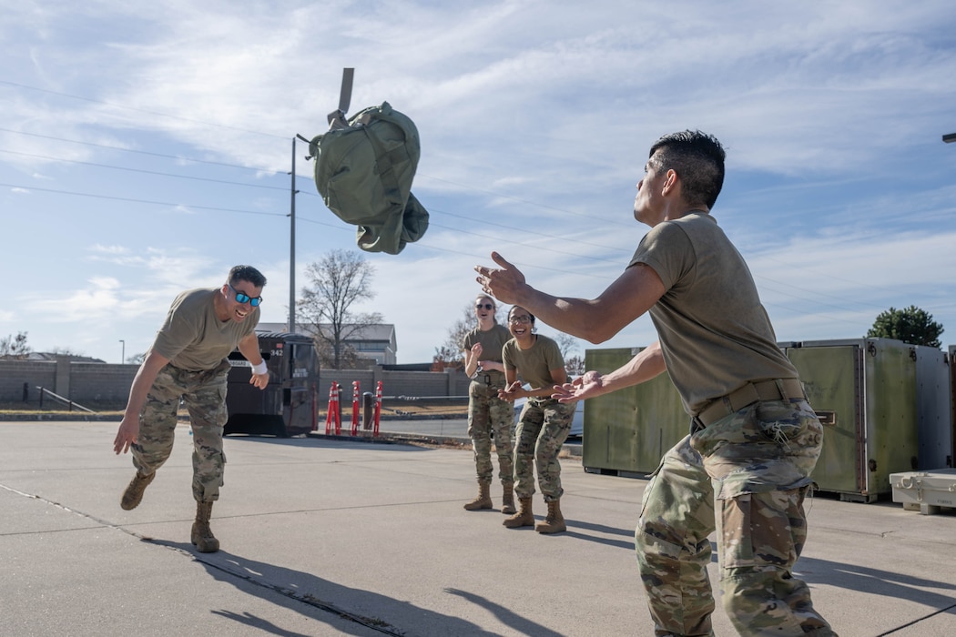 U.S. Air Force Tech. Sgt. Rendy Diaz Vargas, 436th Mission Generation Group Maintenance Qualifications Training Program section chief, tosses a bag full of sand to a teammate during the 2024 Wing Readiness Week at Dover Air Force Base, Delaware, Nov. 6, 2024. Teams from various squadrons across the 436th Airlift Wing faced off in challenges designed to test their operational skills while emphasizing versatility and the ability to fill roles outside of normal duties. (U.S. Air Force photo by Mauricio Campino)