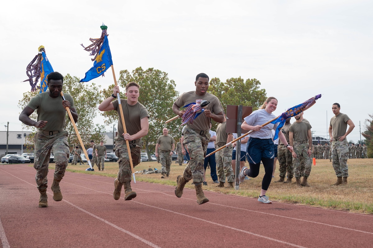 U.S. Airmen compete in a relay race carrying their unit guidons during the 2024 Wing Readiness Week at Dover Air Force Base, Delaware, Nov. 6, 2024. Teams from various squadrons across the 436th Airlift Wing faced off in a warrior challenge to push teams physically and enhance the warrior mindset. (U.S. Air Force photo by Mauricio Campino)