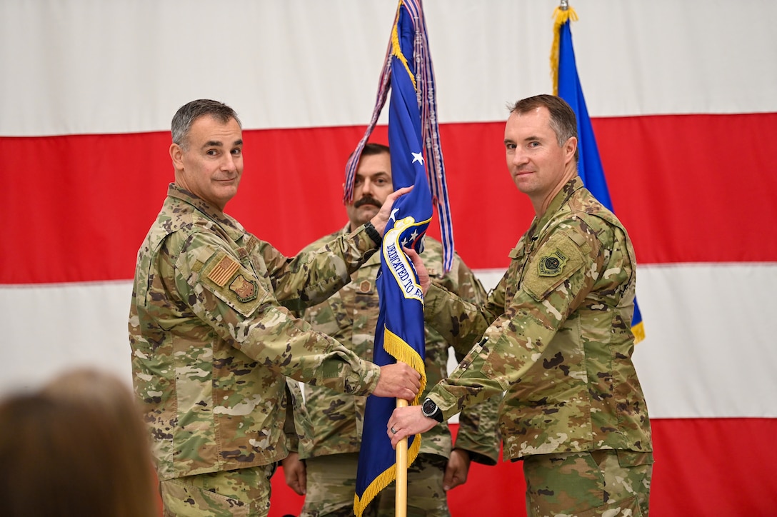 U.S. Air Force Brig. Gen. Erik Peterson, the Wisconsin Air
National Guard Chief of Staff, passes the Wisconsin state flag
to U.S. Air Force Col. Benjamin Gerds, the 115th Fighter Wing
commander, to represent a change of command during a ceremony
in a hangar at Truax Field in Madison, Wisconsin, Nov. 3, 2024.
The wing held its change of command ceremony on base
over a regularly scheduled drill weekend. (U.S. Air National Guard
photo by Master Sgt. Mary Greenwood)