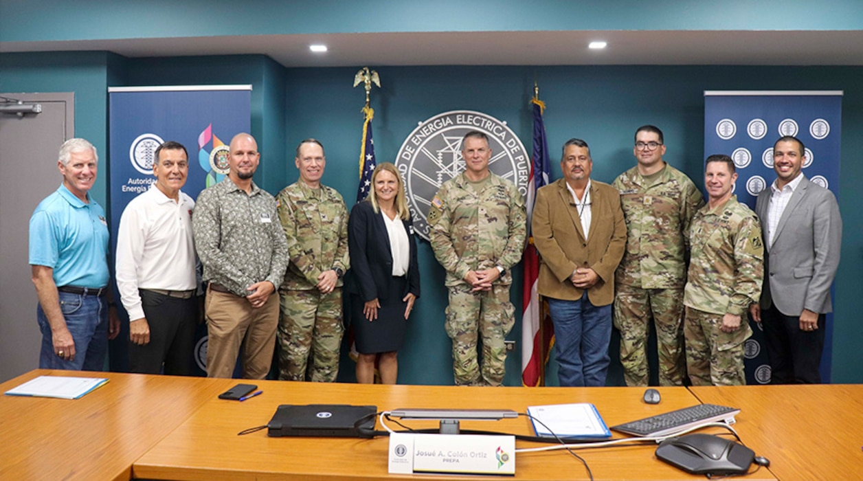 People standing behind a table after signing documents.