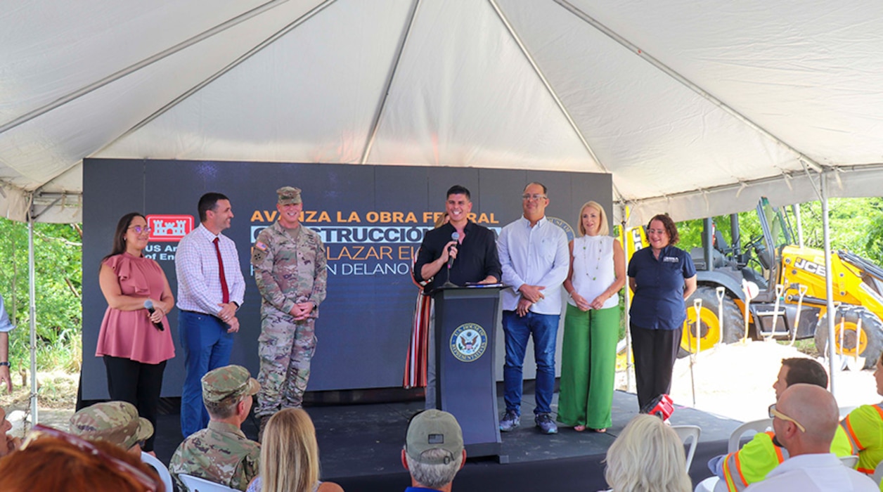 People stand on a stage presenting Groundbreaking Greeting.
