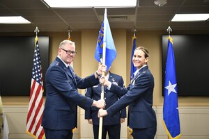 officers hold a guidon during a change of command ceremony