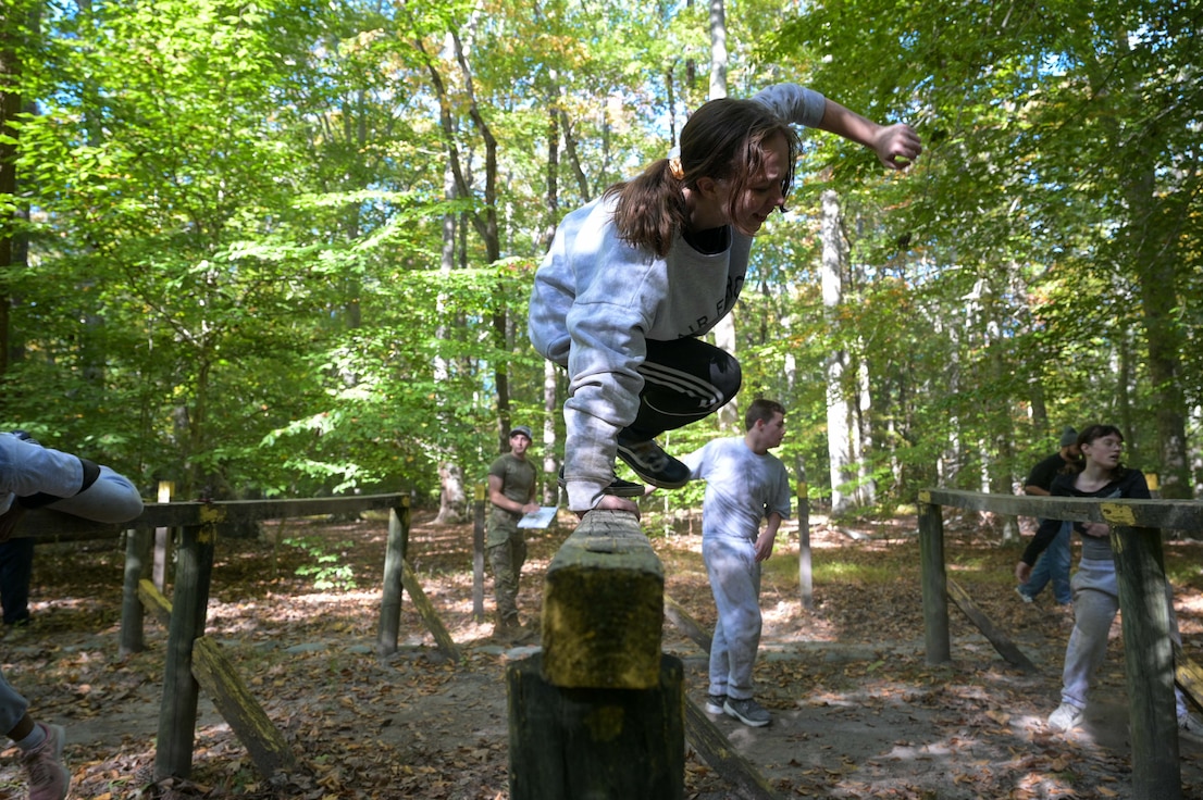 Cadet jumps over a log.