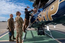 A California Highway Patrol (CHP) officer shows the inside of a CHP helicopter to Chief Master Sgt. Jennifer Barger, 9th Reconnaissance Wing command chief, and Staff Sgt. Braydon Campbell, 9th Aircraft Maintenance Squadron U-2 dedicated crew chief, on Beale Air Force Base, California, Oct. 30, 2024.