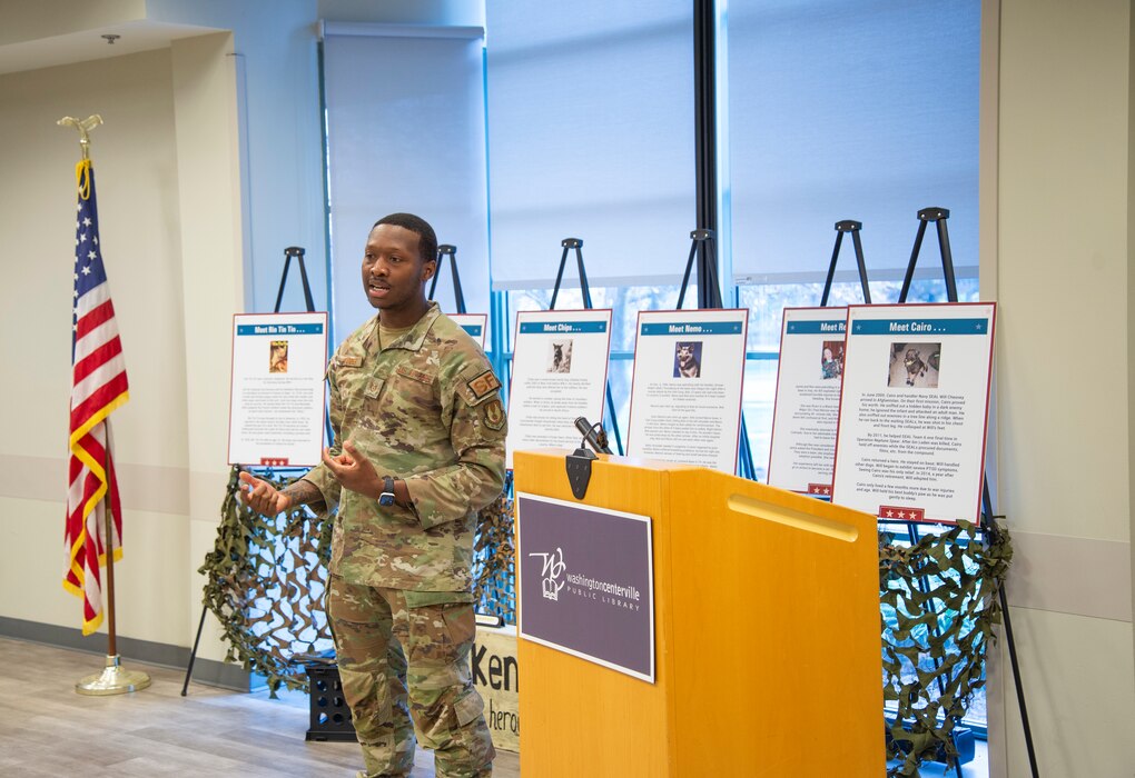 An individual standing in front of the room speaking to people.
