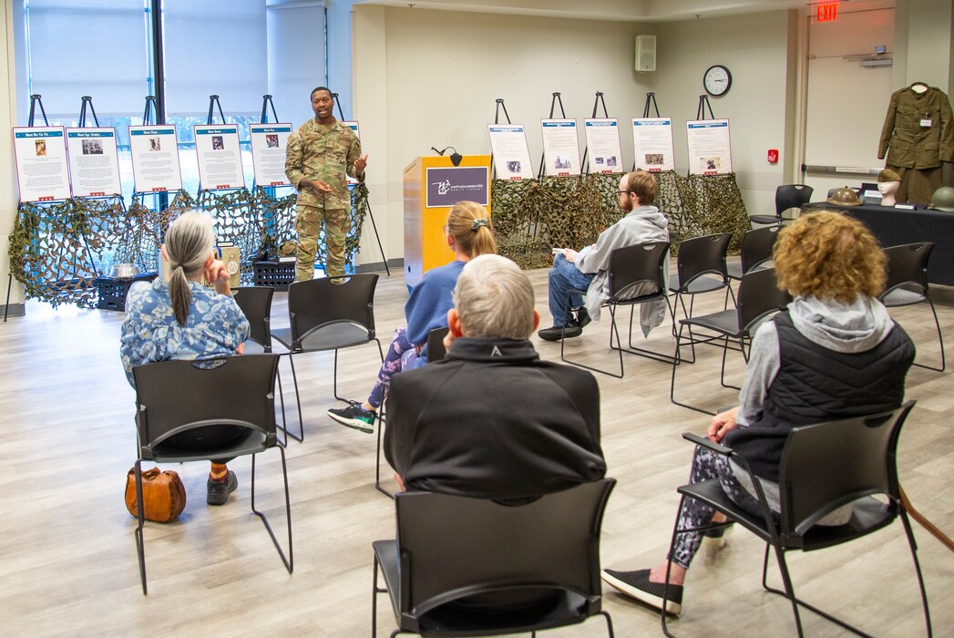 An individual standing in front of the room speaking to people.