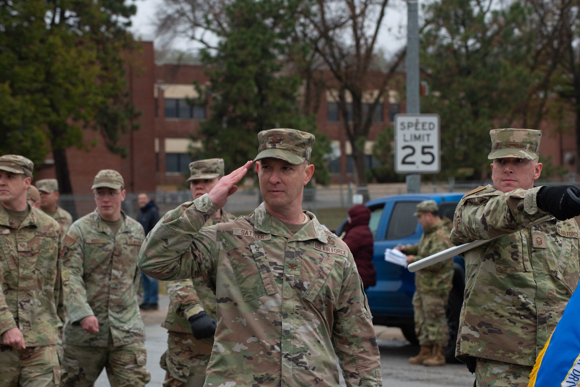 Man renders a salute while marching in Veterans Day parade