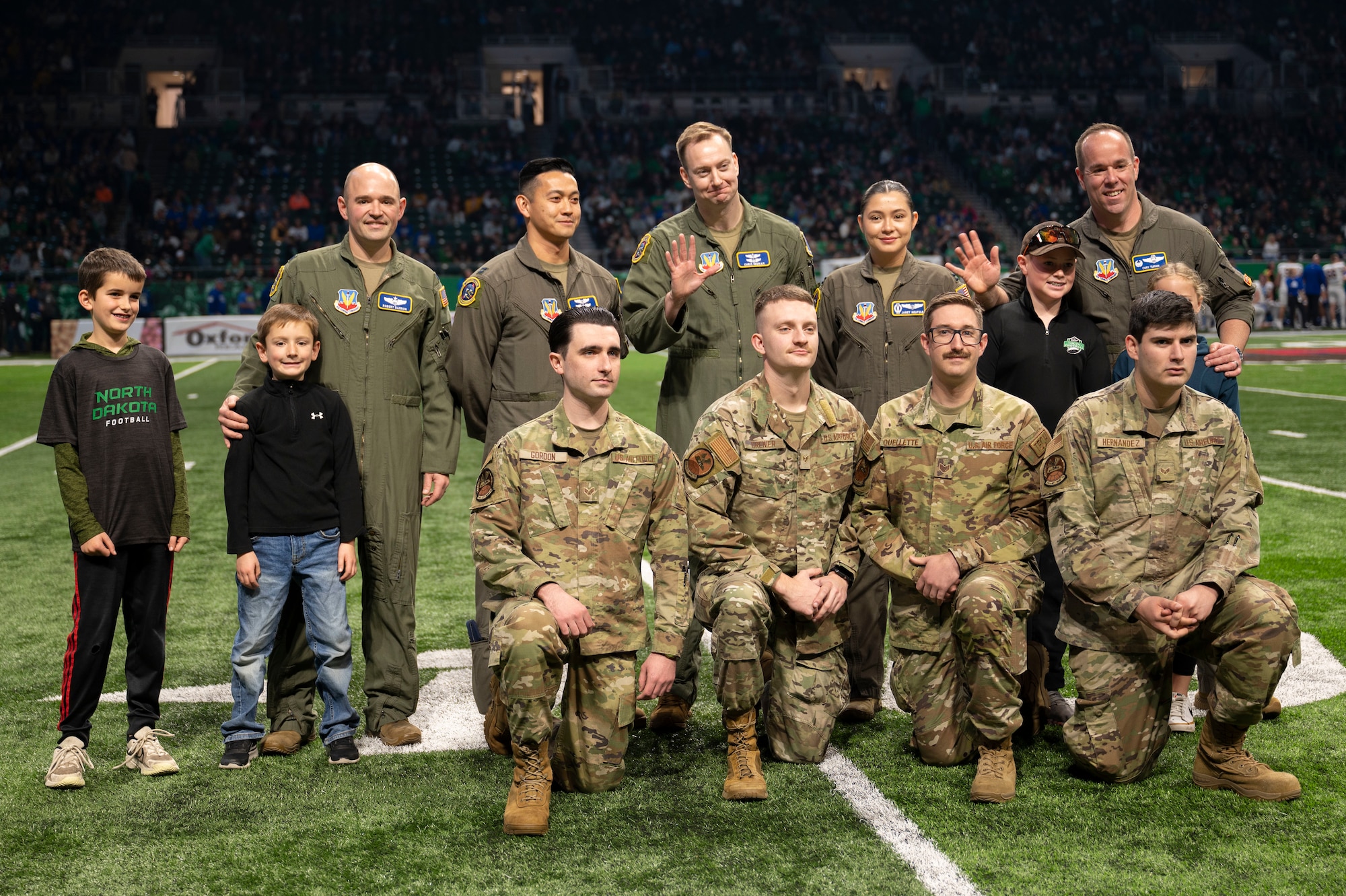 Airmen assigned to the 348th Reconnaissance Squadron, 319th Aircraft Maintenance Squadron and their families pose for a picture at the Alerus Center in Grand Forks, North Dakota, Nov. 9, 2024