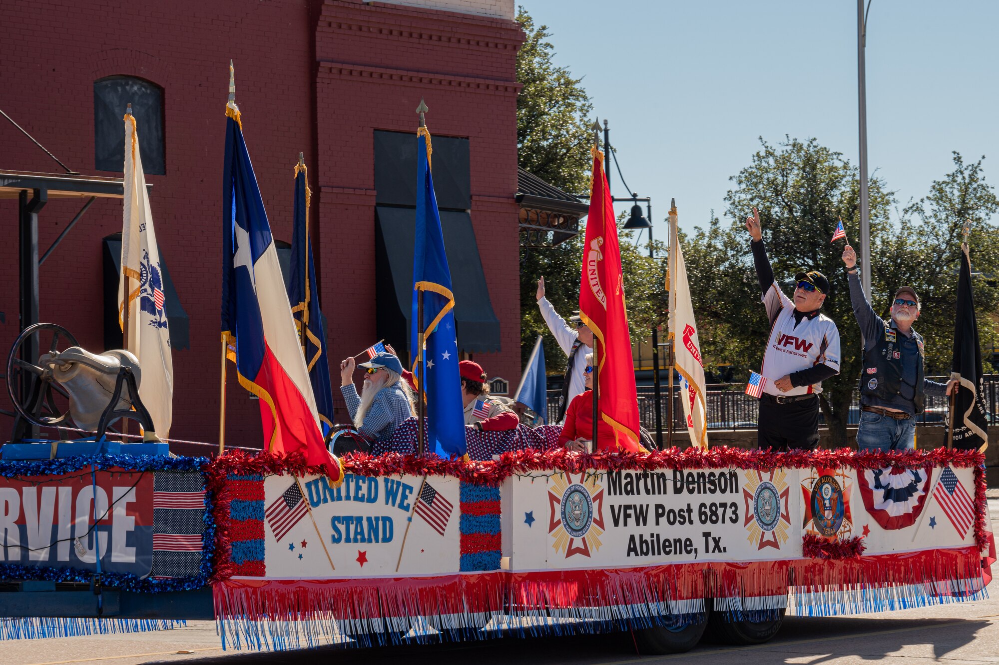 Members of the Veterans of Foreign Wars Post 6873 Martin Denson float wave during the Veterans Day parade at Abilene, Texas, Nov. 9, 2024. Abilene hosts the parade each year to honor the men and women who served in the U.S. military. (U.S. Air Force photo by Senior Airman Alondra Cristobal Hernandez)