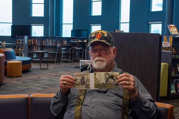 Retired Maj. Bill Briley shares photographs of his father and himself, during their time in the Armed Forces, at the 41st Annual Veterans Day program at Wallers High School, November 11, 2024.