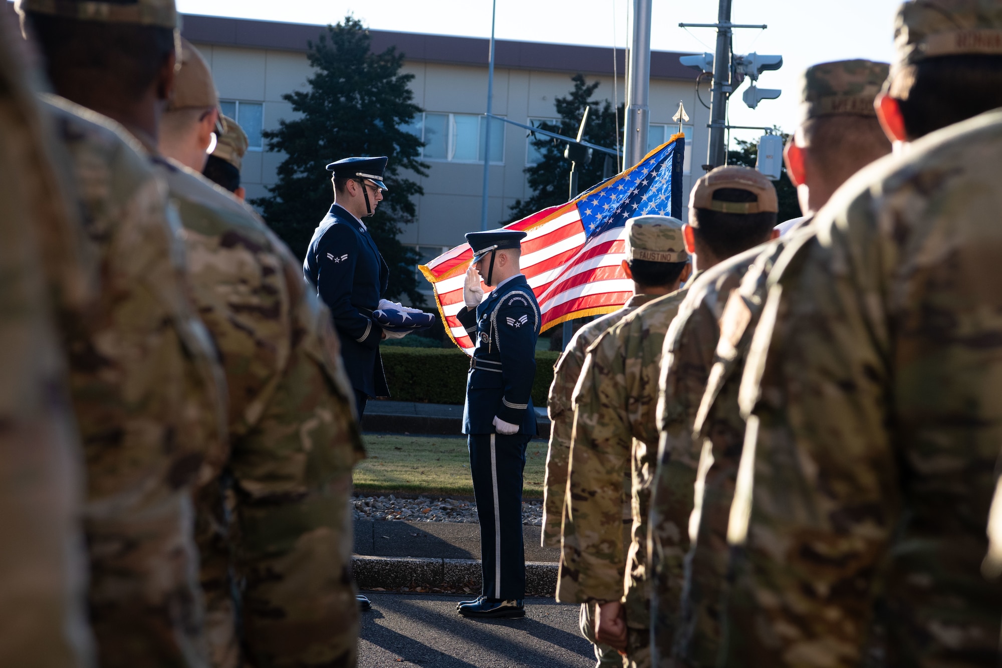 Yokota Air Base honor guardsman, renders a salute to a folded U.S. flag