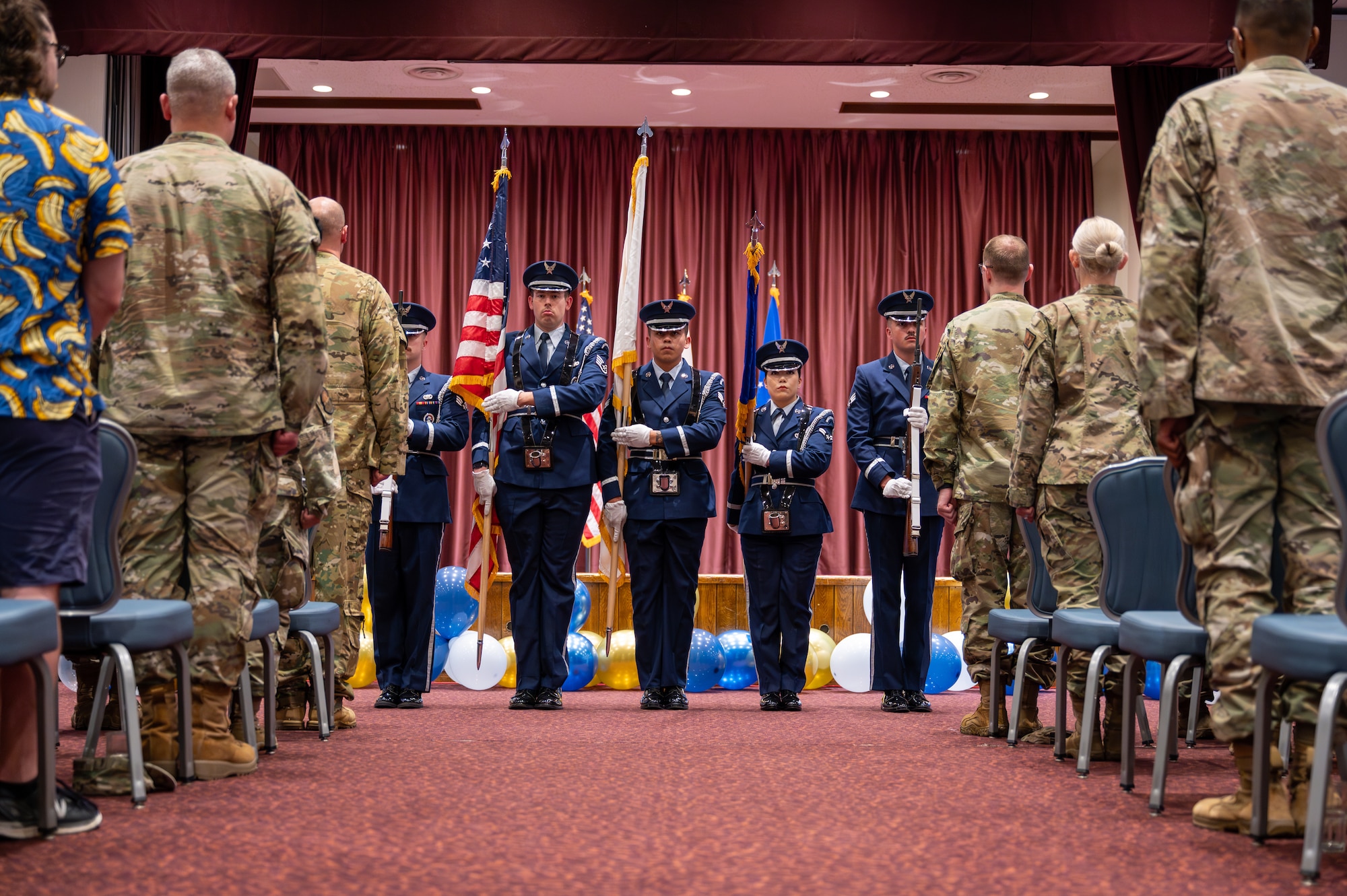 Members of the 374th Airlift Wing base honor guard present the colors during a commencement ceremony for Community College of the Air Force graduates in the Officers' Club at Yokota Air Base, Japan.