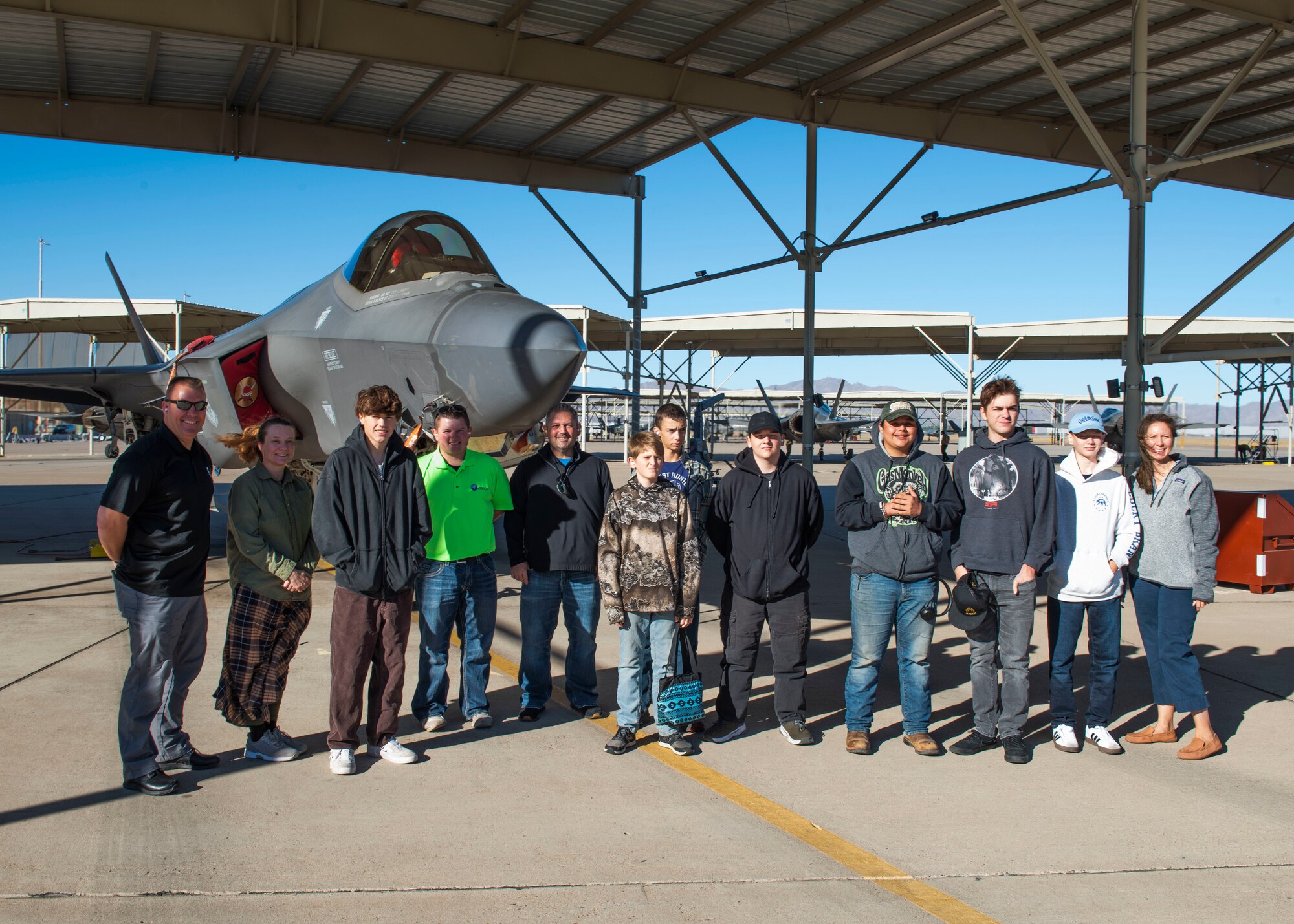 Retired U.S. Air Force Maj. Gen. Brook Leonard (left), prior 56th Fighter Wing commander (2016-2018), and a group of homeschooled students from the local area pose in front of a U.S. Air Force F-35A Lightning II aircraft, Nov. 7, 2024, at Luke Air Force Base, Arizona.