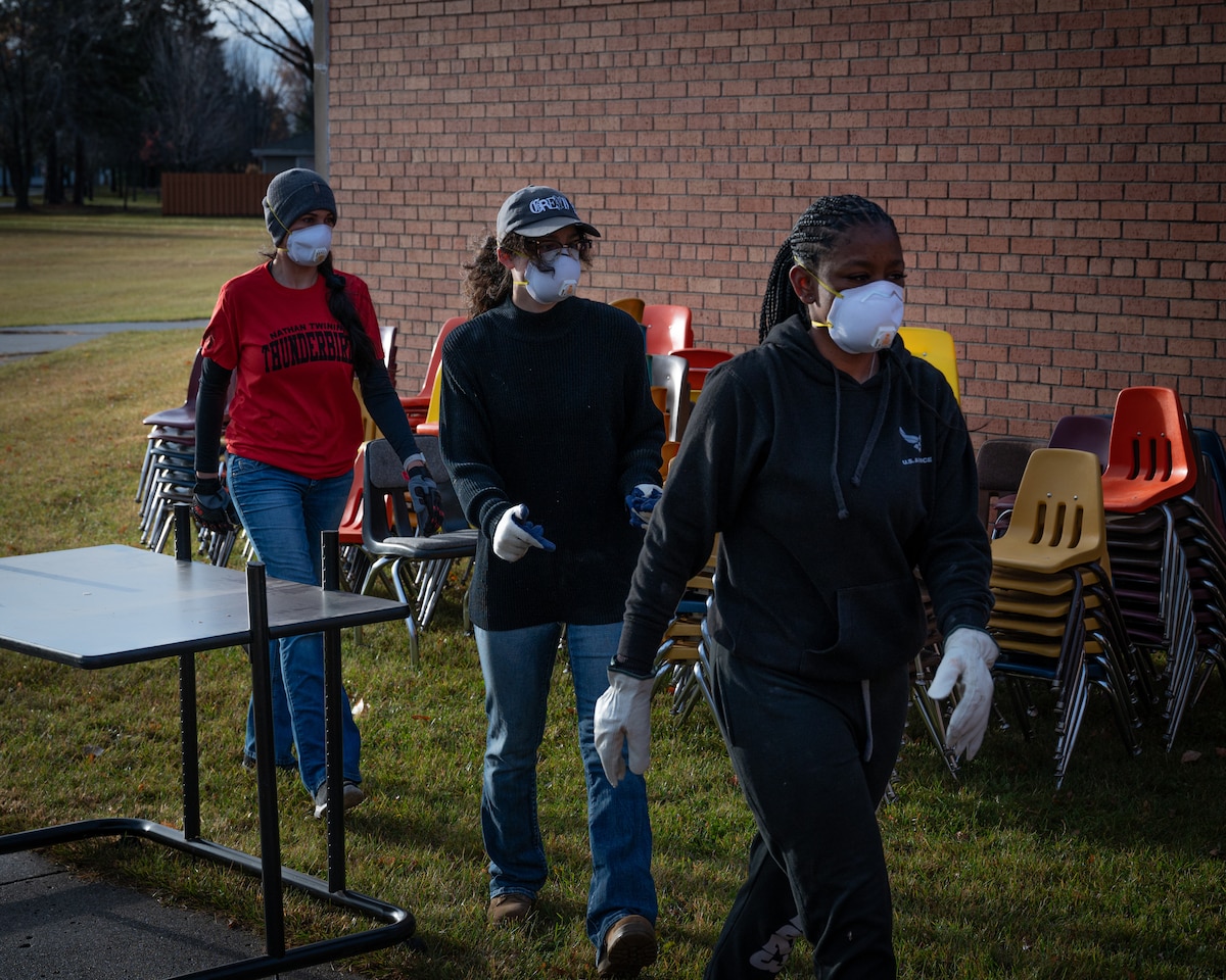 Volunteers from the 319th Reconnaissance Wing prepare to remove garbage, furniture and equipment during the Carl Ben Eielson School clean-up at Grand Forks Air Force Base