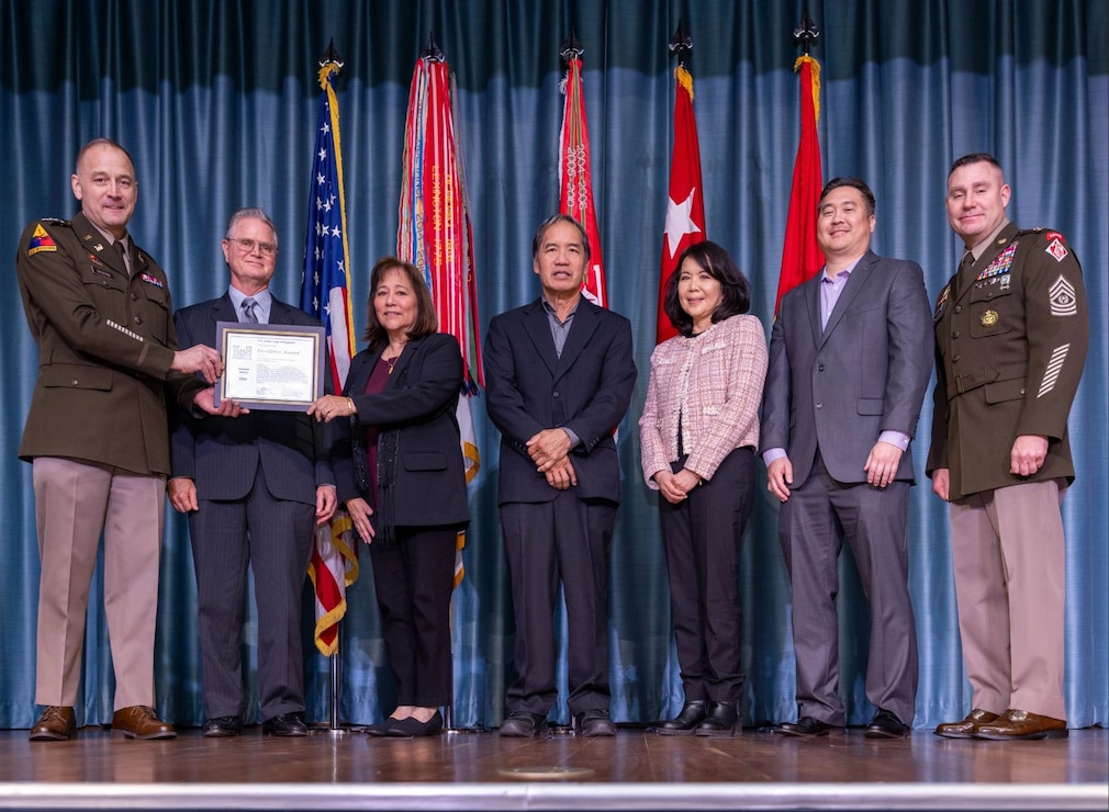 Lieutenant General William H. Graham (far left), 56th Chief of Engineers and Commanding General, U.S. Army Corps of Engineers and Command Sergeant Major Douglas Galick (far right), 15th Command Sergeant Major, USACE present (left to right) Brad Scully, Lise Ditzel-Ma, Gerald Young, Jodi Yoshishige, and David Matsumoto the 2024 USACE Project Delivery Team of the Year Award at the 2024 USACE National Award Ceremony in Washington, DC Nov. 13, 2024. This was to commemorate the PDT’s work on the Command and Control Facility Project on Fort Shafter, Hawaii, which is the new U.S. Army Pacific Headquarters building now named the Frederick C. Weyand Command Center. (Photo courtesy of USACE HQ).