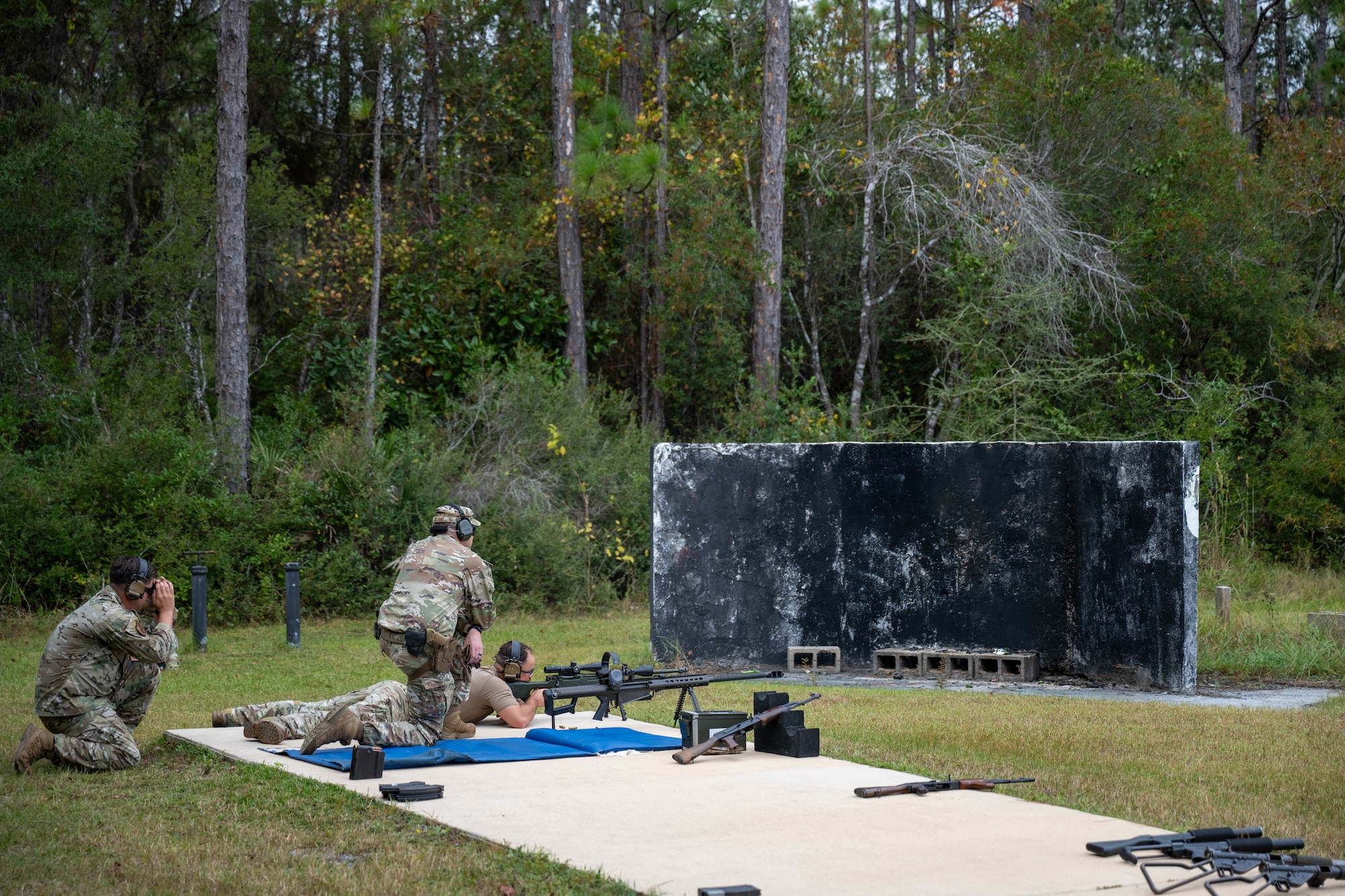 A U.S. Air Commando shoots a target while range safety officers observe his accuracy during the Service Member of the Year competition at Hurlburt Field, Florida, Oct. 30, 2024.