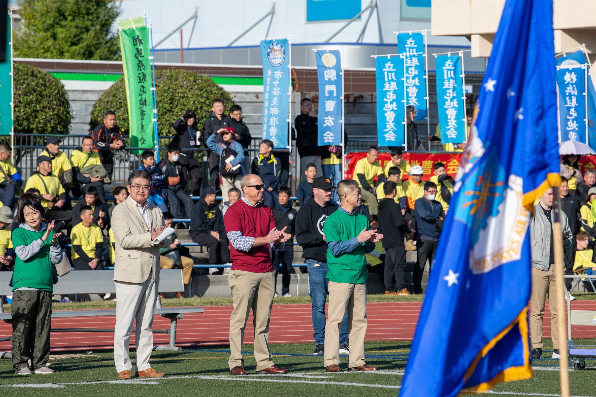 From left, Ikuo Kato, Fussa City mayor; U.S. Air Force Col. Brett Cochran, 374th Airlift Wing deputy commander; and Japan Air Self-Defense Force Col. Hiroyuki Ishii, Operations Support Wing commander, applaud.