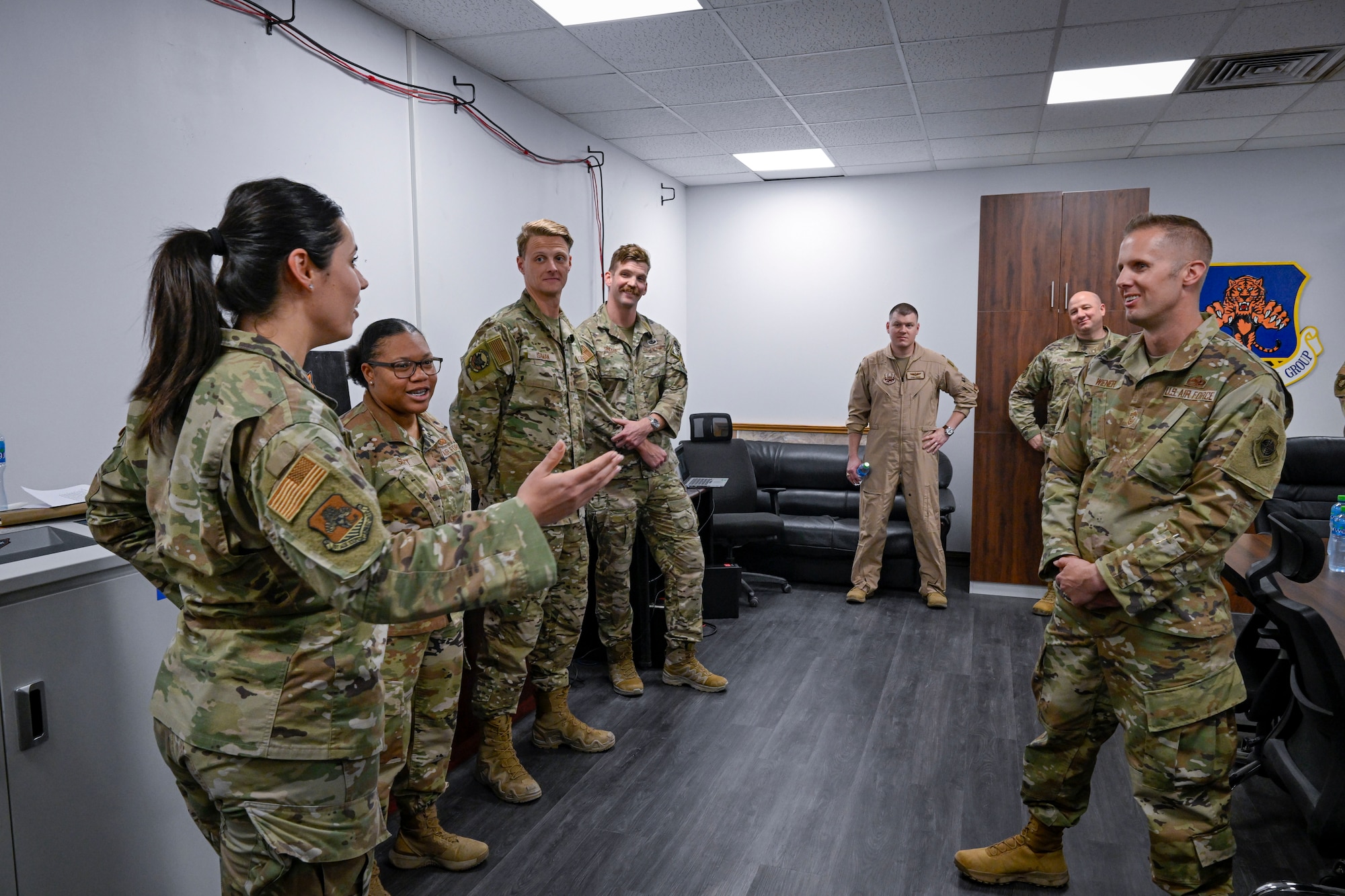 Military members have a conversation during a visit to a work center.