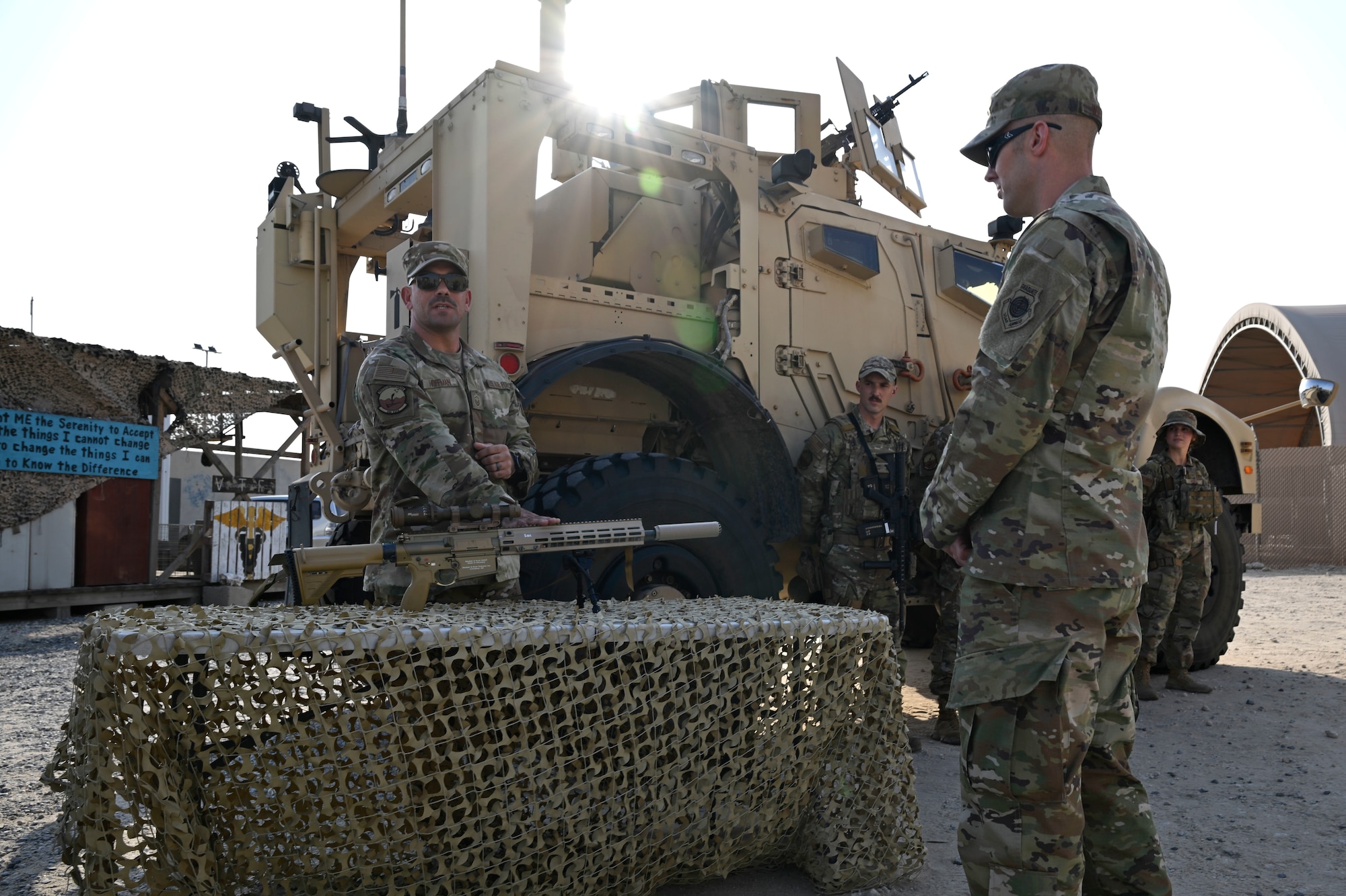 A military members is briefed during a visit to a work center.