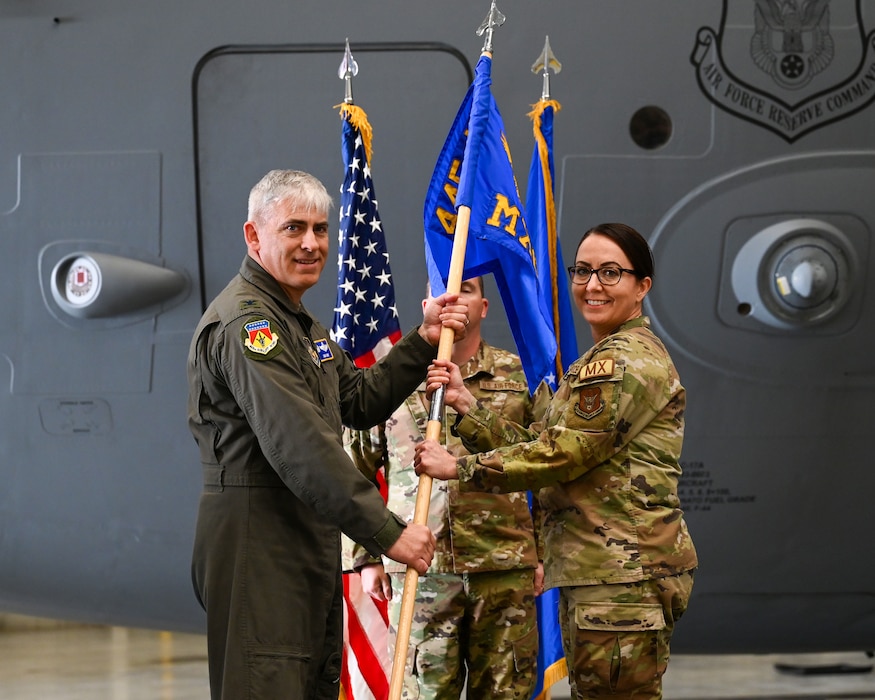 Col. Douglas A. Perry, 445th Airlift Wing commander, passes the guidon to Lt. Col. Karen Gharst, incoming 445th Maintenance Group commander, during the 445th MXG assumption of command ceremony at Wright-Patterson Air Force Base, Ohio, Nov. 3, 2024. Prior to her new role in the wing, Gharst served as the 445th MXG deputy commander.