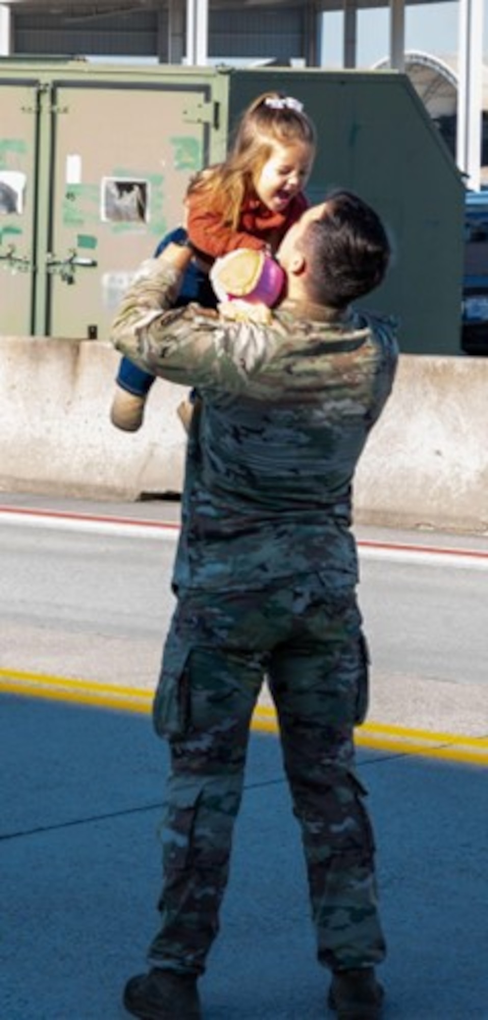 Airman picks up and raises his daughter to the sky. (U.S. Air Force photo by Airman Donnell Ramsey)