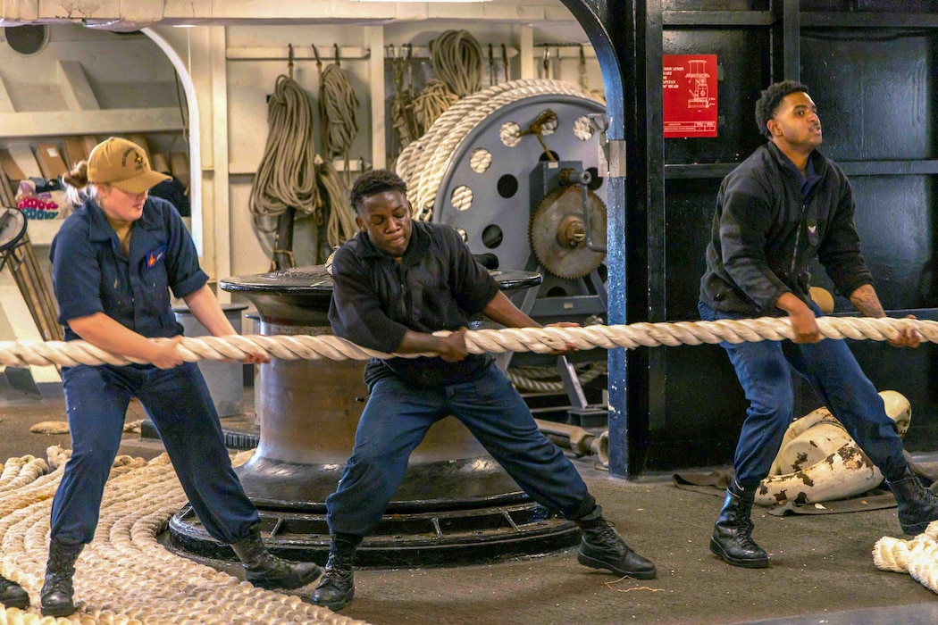 Sailors aboard USS George H.W. Bush (CVN 77) handle line during a sea and anchor evolution while departing Norfolk Naval Shipyard.