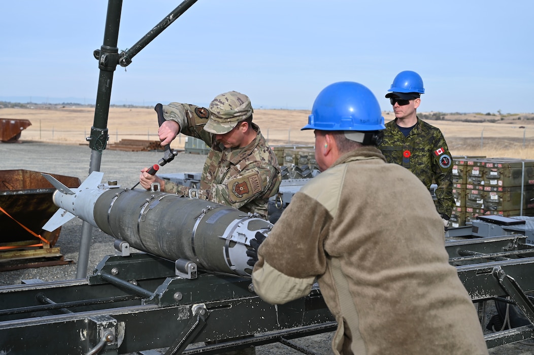 U.S. Air Force Airmen, and Sgt. Kristjan Lindvere of the Royal Canadian Air Force, man the munitions assembly conveyor during hands on training with the Air Force Combat Ammunition Center (AFCOMAC) at Beale Air Force Base, California, Nov. 5, 2024.